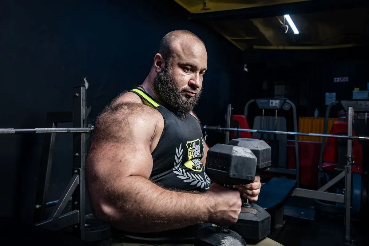 Lifter training with a heavy dumbbell