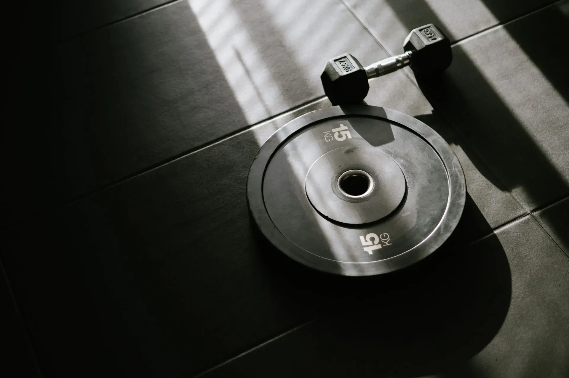 Barbell and plates on a black gym floor
